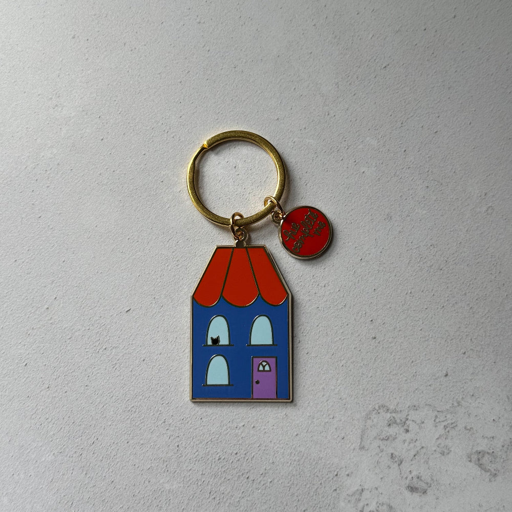 Keychain with a colorful house design on a gray background